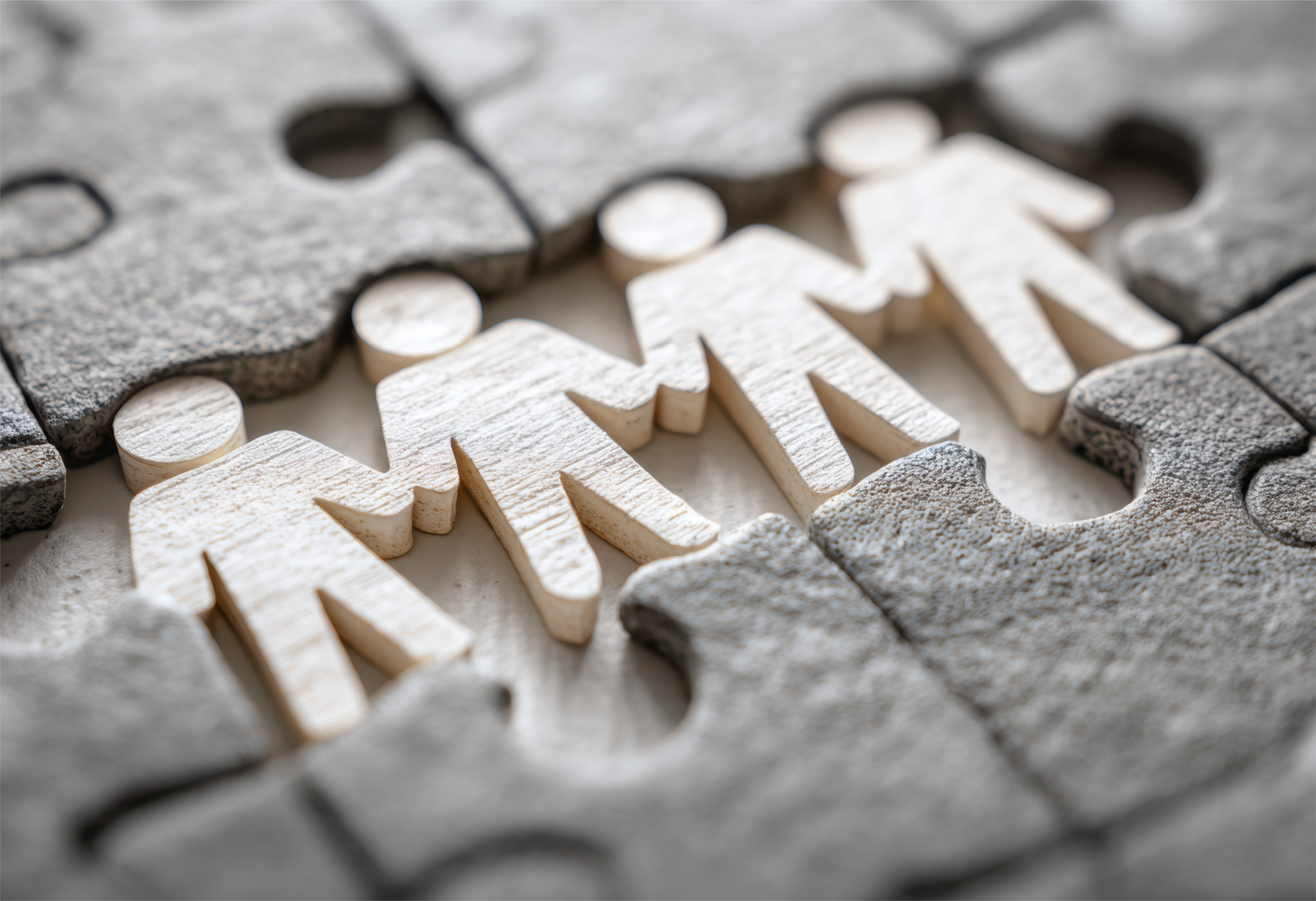Paper people holding hands in puzzle